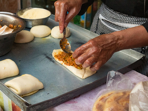 Mains travaillant la pâte avec de l’huile dans une cuisine de Marrakech