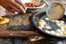 Cuisson de boulettes dans une bassine d’huile sur le feu près de Malabo